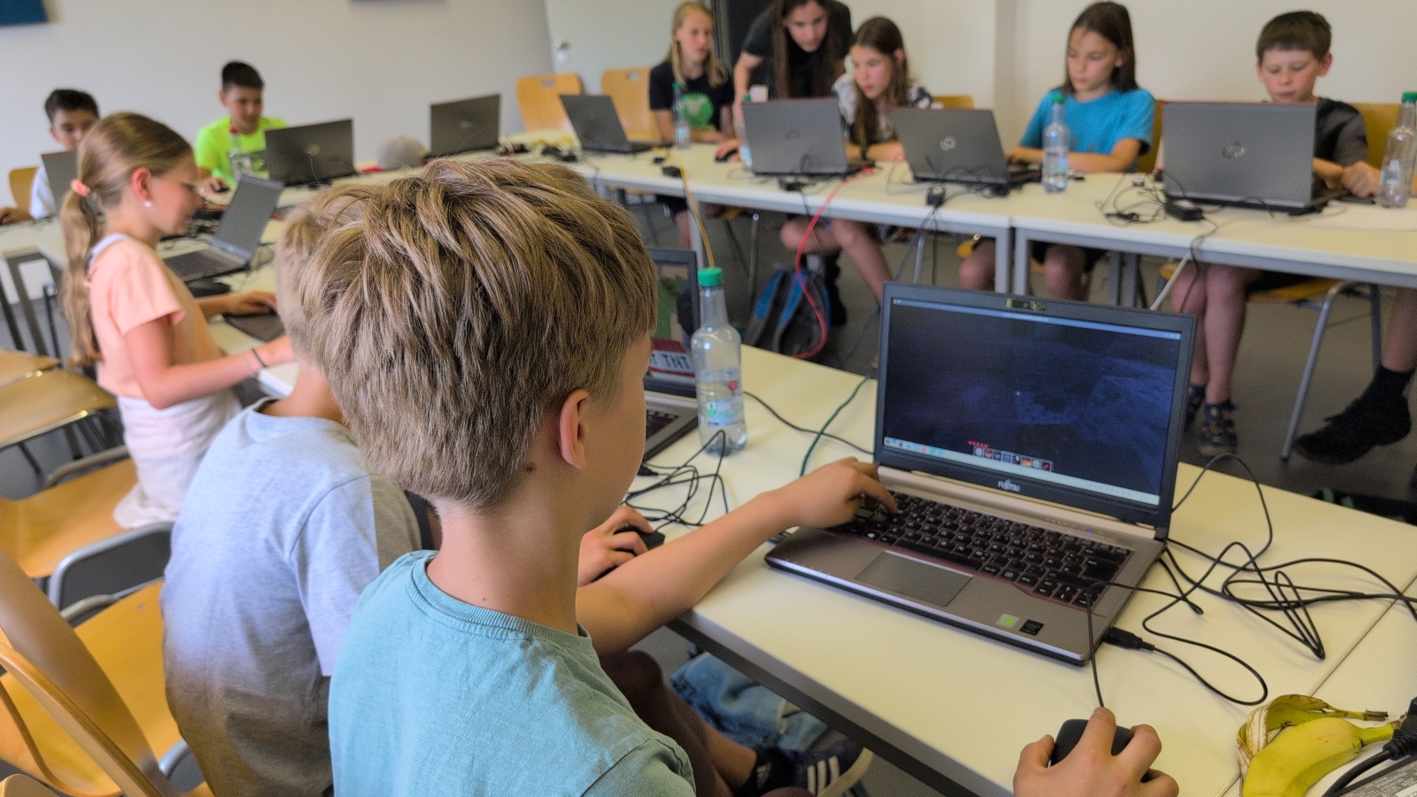 Kinder im Workshop-Raum mit Luanti auf Laptop