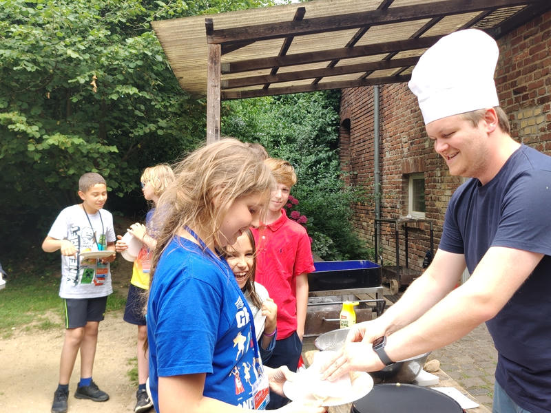 Niklas mit Kochmütze verteilt Crêpes
