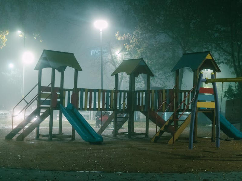 Ein leerer Spielplatz im Dunkeln und im Nebel