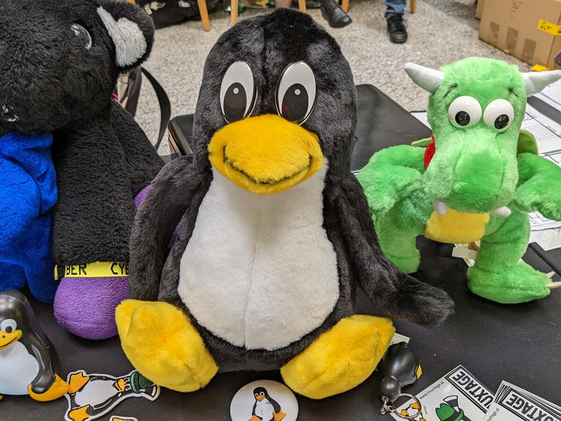 Linux-Pinguin Tux aus Plüsch, daneben auch Konqi von KDE und ein blauer PostgreSQL-Elefant